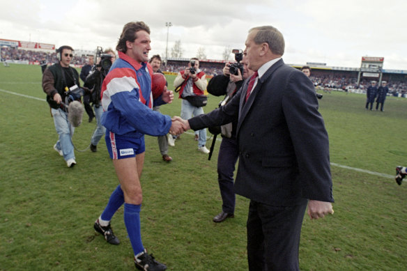 Doug Hawkins shakes hands with Ted Whitten in 1994.