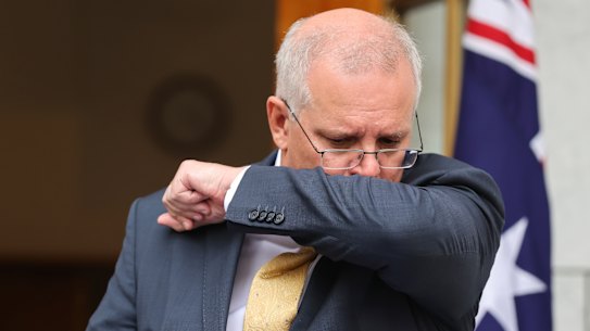 Prime Minister Scott Morrison coughs during a news conference at Parliament House in Canberra, hours before testing positive for COVID-19.