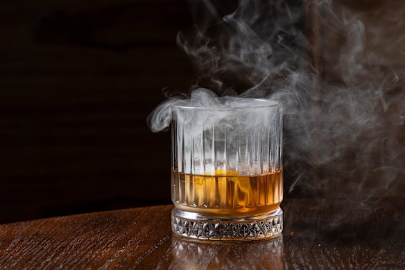 The “Doot on Fire” cocktail with bourbon, bitters, simple syrup, cherry smoke and orange.