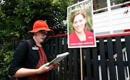 Greens candidate for South Brisbane, Amy MacMahon, walks past a corflute of Deputy Queensland Premier Jackie Trad while doorknocking in the electorate of South Brisbane, during the Queensland state election in Brisbane on Wednesday 22 November 2017. fedpol Photo: Alex Ellinghausen