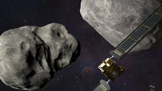 Artist’s rendering of NASA’s DART probe, foreground right, and Italian Space Agency’s LICIACube, bottom right, at the Didymos system before impact with the asteroid Dimorphos, left.
