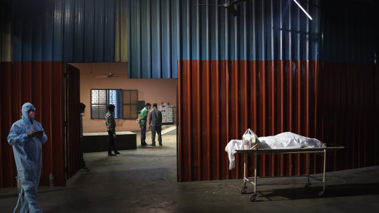 Workers prepare to cremate the body of a COVID-19 victim in New Delhi on Monday.