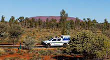 ULURU, AUSTRALIA - JUNE 06: Northern Territory Police drive past Uluru. Uluru, also known as Ayres Rock is sacred to the Pitjantjatjara the Aboriginal people of the area, known as athe Anangu it lies in the Uluru- Kata Tjua National Park on June 06, 2024, in Uluru, Australia (Photo by Steve Christo - Corbis/Corbis via Getty Images)