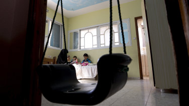 Muna Awad sits with her children in her daughter Aisha's room at the family house in Bureij refugee camp in Gaza.