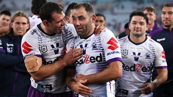 Cameron Smith appears to be holding his injured ribs during the presentation following Sunday's grand final.
