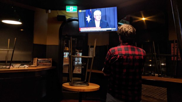 Peter Sherwood watches the prime minister's announcement from his empty front bar.