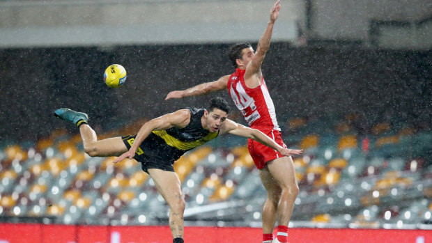 Goal drought: Richmond's Jason Castagna battles Sydney defender Jake Lloyd in a game that saw just seven majors scored at a wet Gabba on Sunday.