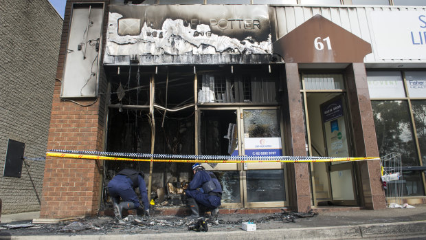 Investigators look through the rubble to determine the cause of a fire that destroyed Jenny Magic Massage in Phillip.