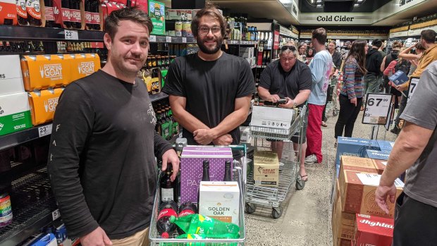 Housemates Jai Ashman and  Simon Giacomo, both 31, in line at the bottle shop on Sunday evening.