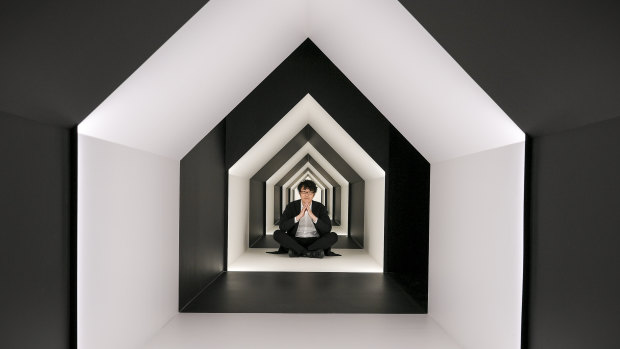 Nendo head designer Oki Sato sitting in a real-life optical illusion.