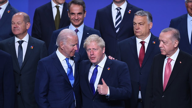 Joe Biden chats to British Prime Minister Boris Johnson during a family photo at the NATO summit in Madrid.