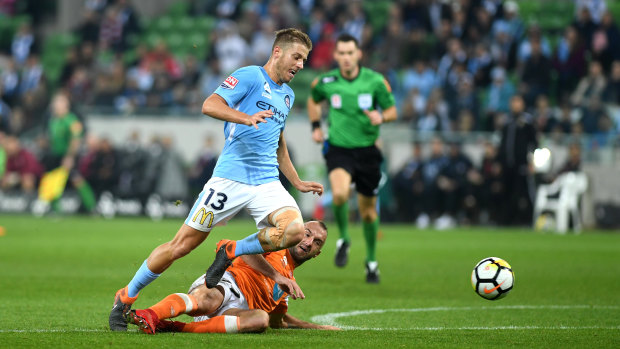 City's Stefan Mauk is tackled by Roar's Ivan Franjic.