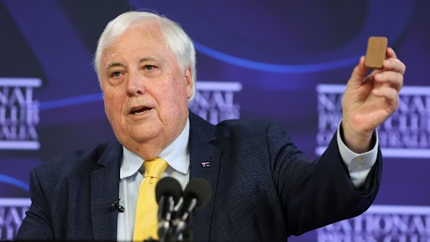 Clive Palmer holds up a Tim Tam during an address to the National Press Club of Australia.