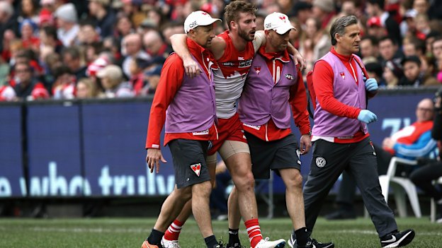 Alex Johnson is helped off the field after injuring his anterior cruciate ligament while playing for the Swans in 2018.