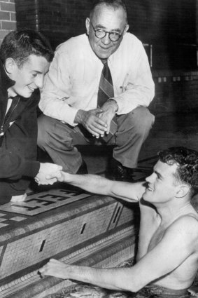 John Marshall (left), of Yale, congratulates John Davies, University of Michigan, who grabbed the honours in the 220 yard breast stroke. Sir Frank Beaurepaire (centre) was on hand to cheer for his countrymen, 1951.