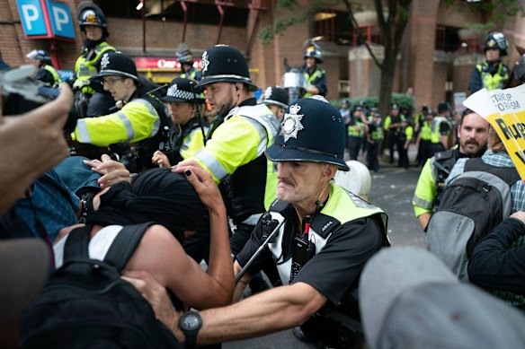 Mounted police officers scuffle with demonstrators during a protest by anti-migrant Abolish Asylum System and counter protesters at Castle Park in Bristol, England.