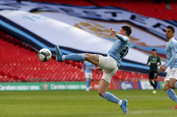 Manchester City’s Phil Foden reaches for the ball.