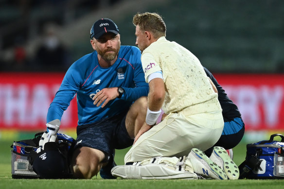 Joe Root seeks medical attention after being hit by a delivery by Mitchell Starc.