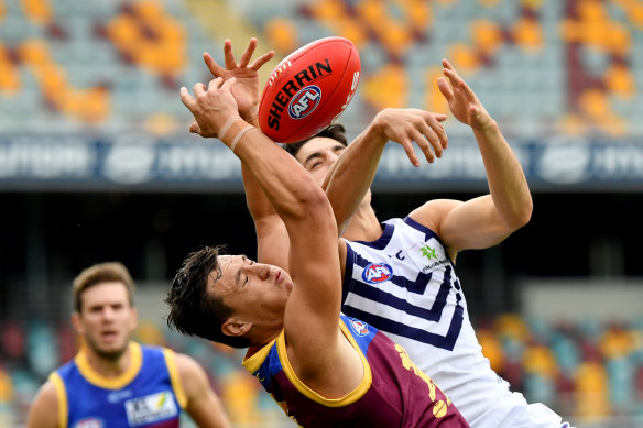 Hugh McCluggage (left) of the Lions is hampered by the Dockers' Andrew Brayshaw during their round 2 match  at the Gabba on Saturday.
