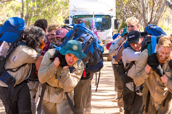 Manly players drag a five-tonne truck, loaded with another two tonnes of equipment, through the bush near Mudgee.