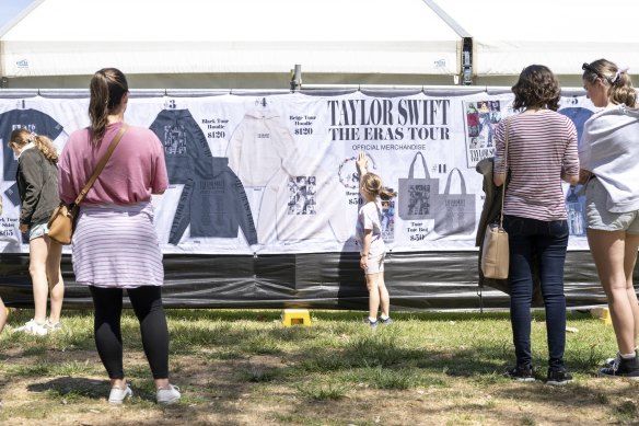 A young girl at the MCG Taylor Swift merchandise stand points out what she wants on Thursday.