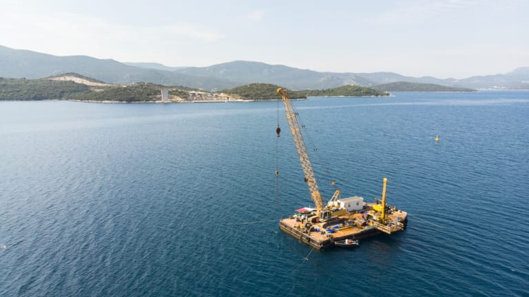 A platform works in the channel where the bridge will be built.