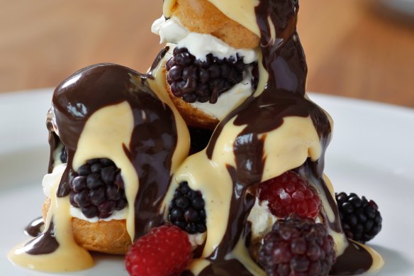 Profiteroles with fresh berries, custard and chocolate sauce.