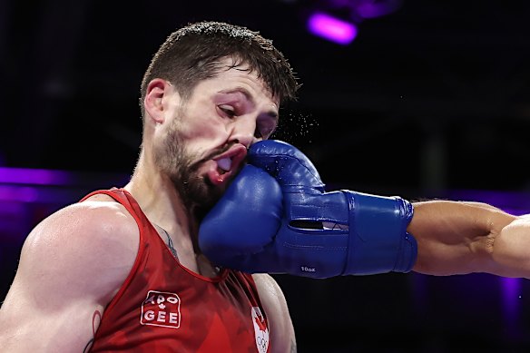 Wyatt Sanford of Canada is punched by Ruslan Abdullaev of Uzbekistan.