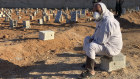A man sits by the graves of the flash flood victims in Derna.