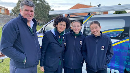 St Leonard’s College principal Peter Clague with student volunteers who rode in Lennie’s Van to prepare breakfast for residents at a local council estate.