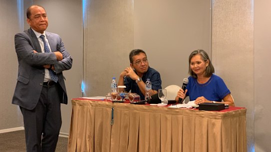 Exiled Cambodia opposition leader Mu Sochua, right, speaks at a press conference in Jakarta, next to  Indonesian activist Darmawan. Cambodian ambassador to Indonesia Hor Nam Bora - who tried to stop the event - looms over the pair.