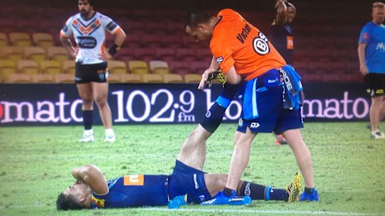 Play is stopped while Gold Coast centre Young Tonumaipea receives urgent treatment for cramp.