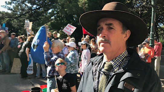 Galilee Basin cattle farmer Bruce Currie protests outside Queensland's Parliament House as scientists evaluate Adani's Carmichael mine groundwater study.