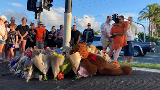 Locals gather at the intersection for a vigil on Thursday afternoon.