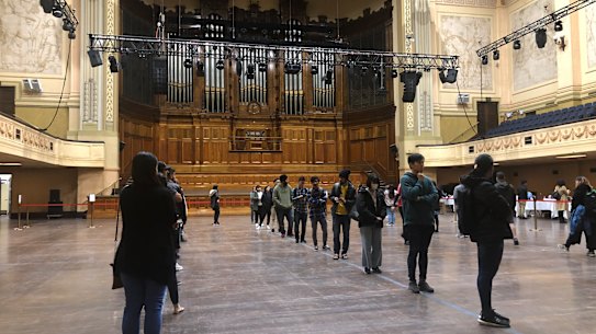 Students wait for food vouchers inside Melbourne Town Hall on Thursday. 