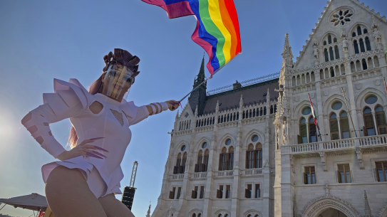 A drag queen waves a rainbow flag outside Hungary’s parliament last year.