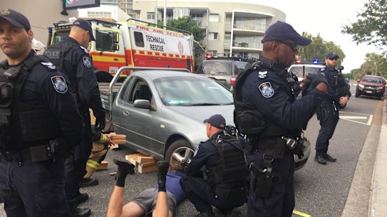 The protester locked themselves to a car outside an International Women’s Day breakfast hosted by the Queensland Resources Council.