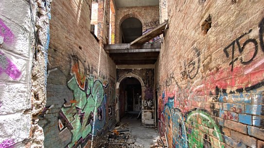 The original brickwork shows arched doorways and keystone brick layout.