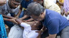 People help a woman who fainted as she was praying. 