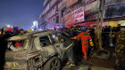 Rescue workers gather at the site of a burnt vehicle targeted by a US drone strike in east Baghdad.