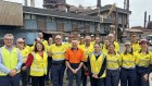 Federal Minister Chris Bowen (in orange shirt) at BlueScope’s Port Kembla steelworks. 