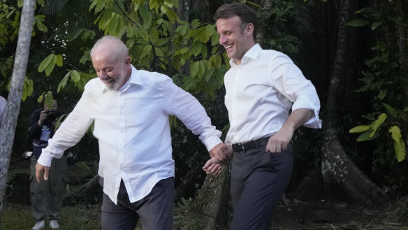 Brazilian President Luiz Inacio Lula da Silva, left, and French President Emmanuel Macron arrive on Combu Island, Para state, Brazil, on Tuesday. The image was co-opted by memes poking fun at their “very close” relationship.