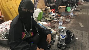 Peggy sits on a bridge at Polytechnic University, surrounded by crude weapons.