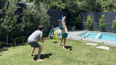 Oliver, Rafferty and Spencer Ries play cricket on Christmas Day in isolation at home in Hampton.
