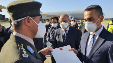 Italy's Foreign Minister Luigi Di Maio receives a letter from a Turkish army officer as Italian soldiers unload donated personal protection equipment in Rome.