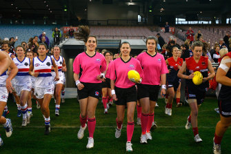 Umpires and players run out of the race at the MCG in 2013, before the women’s exhibition match between the Demons and Bulldogs.