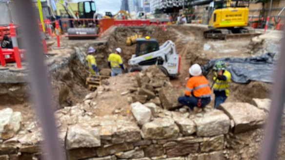 A bulldozer breaking up and removing the remains under Adelaide Street.