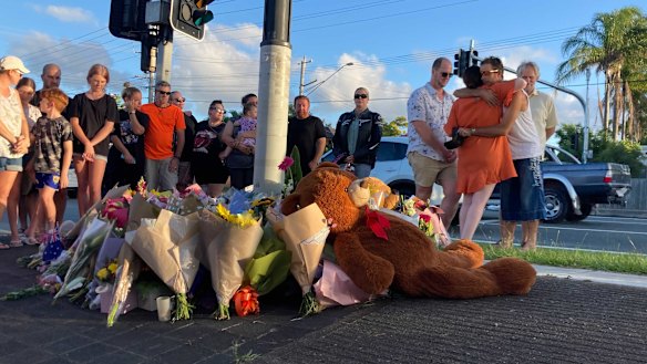 Locals gather at the intersection for a vigil on Thursday afternoon.