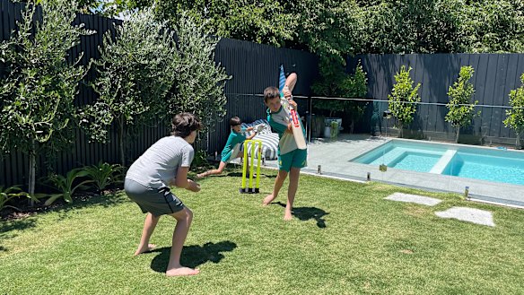 Oliver, Rafferty and Spencer Ries play cricket on Christmas Day in isolation at home in Hampton.