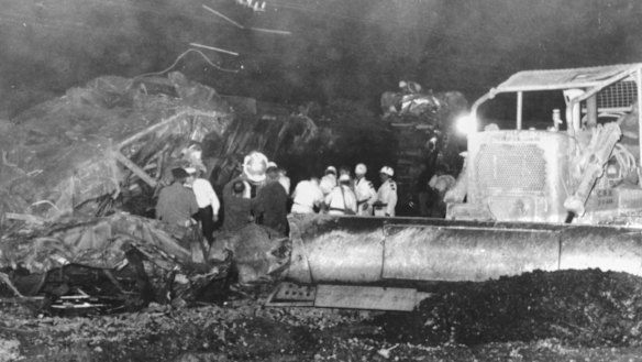 Rescue work continues through the night. The bulldozer was used to push the wreckage off the rail tracks.